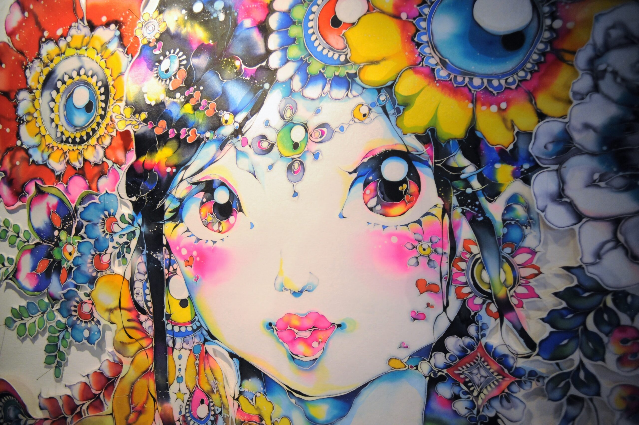 ろうけつ染めアーティスト大竹夏妃さんの作品。 花飾りを身に付けた少女が鮮やかな染料で描かれている。