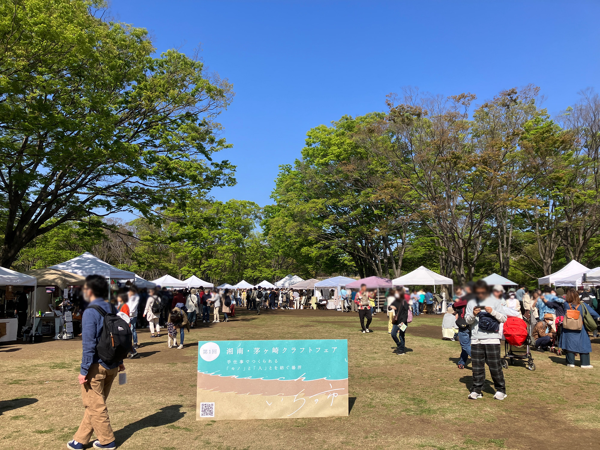 いちの市の看板と行き交う人々